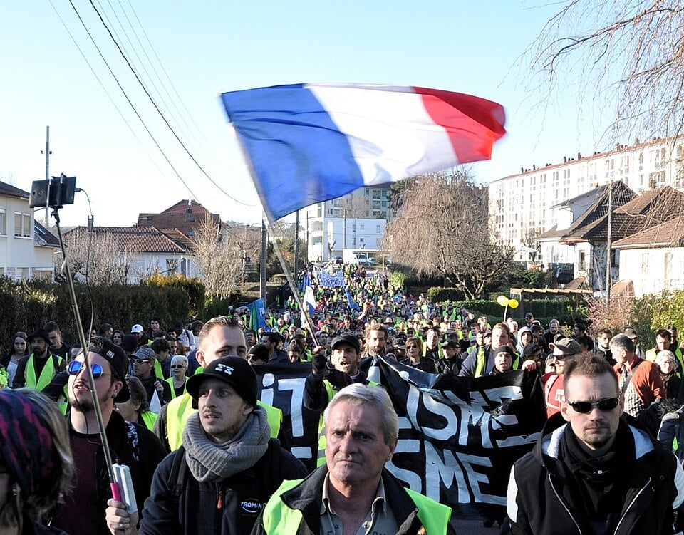 Manifestation des Gilets jaunes — foule de manifestants portant des gilets jaunes dans une rue de ville française